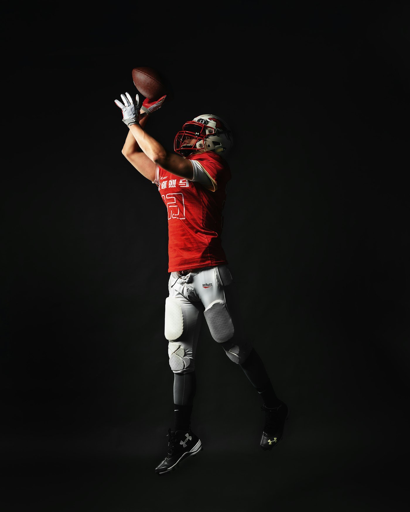Football player jumping to catch a pass, representing timing a fantasy football trade correctly