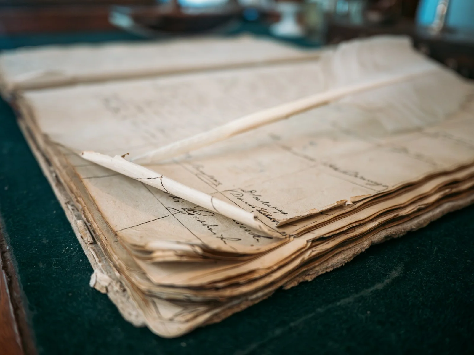 An old handwritten ledger book with a quill pen, representing FantasyCalc recording real completed trades