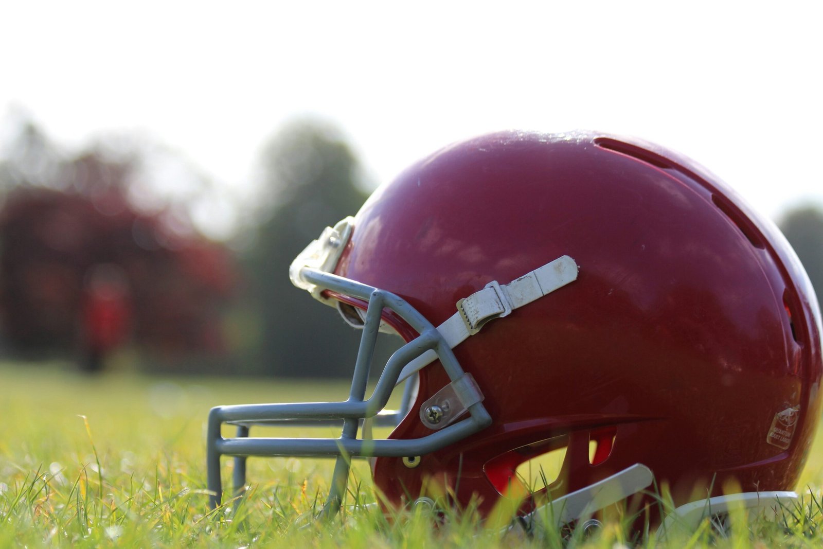 Football helmet resting on a grass field, representing expert-level trade evaluation